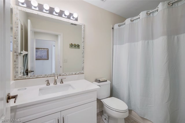 bathroom with vanity, tile floors, and toilet