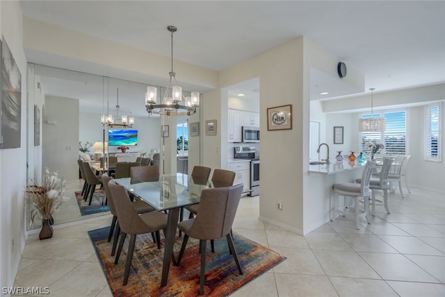 dining room featuring an inviting chandelier, sink, and light tile floors