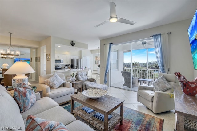 living room featuring light tile flooring and ceiling fan with notable chandelier