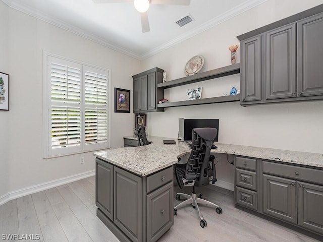 office space with ceiling fan, crown molding, built in desk, and light hardwood / wood-style floors