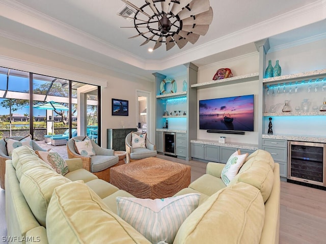 living room featuring light hardwood / wood-style flooring, wine cooler, bar area, and ceiling fan