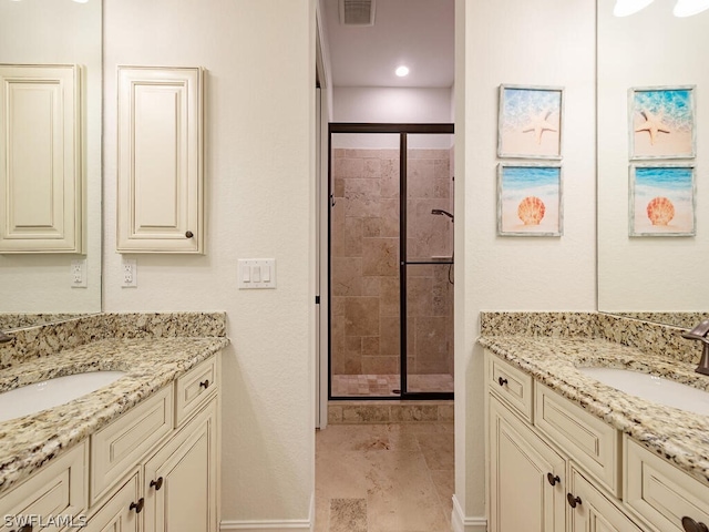 bathroom with a shower with shower door, tile floors, and vanity