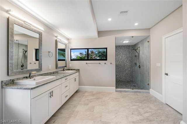 bathroom with vanity and a tile shower