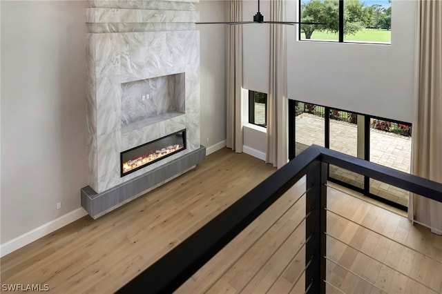 unfurnished living room featuring light hardwood / wood-style floors, a healthy amount of sunlight, and a tile fireplace