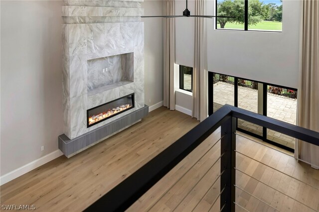 interior space featuring baseboards, wood finished floors, and a glass covered fireplace