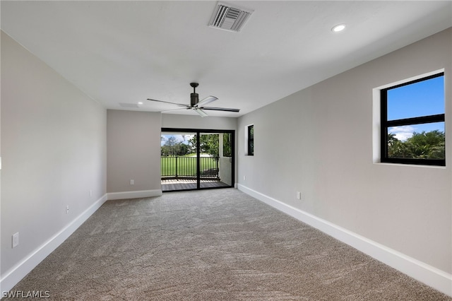 empty room featuring carpet floors, visible vents, ceiling fan, and baseboards