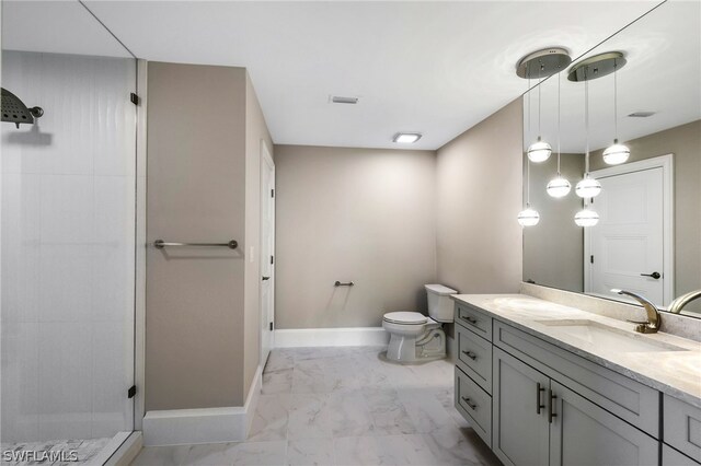 bathroom with marble finish floor, toilet, a tile shower, vanity, and baseboards