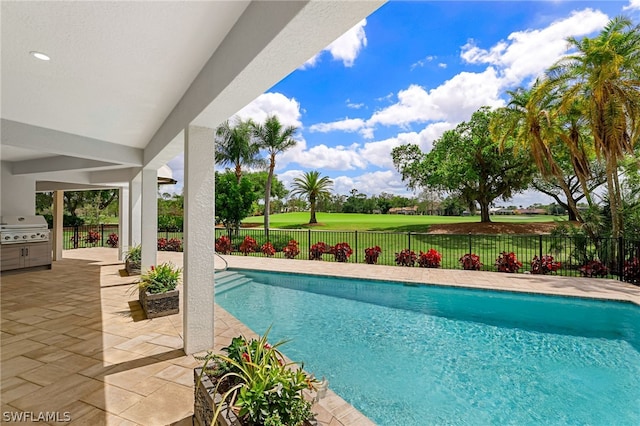 view of swimming pool with a yard, a patio area, and grilling area