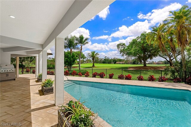 view of swimming pool featuring a fenced in pool, a patio area, a fenced backyard, and grilling area