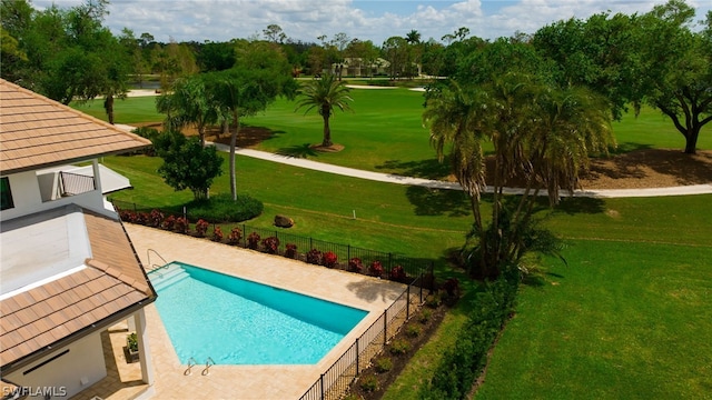 view of swimming pool featuring a patio, fence, a fenced in pool, and a yard