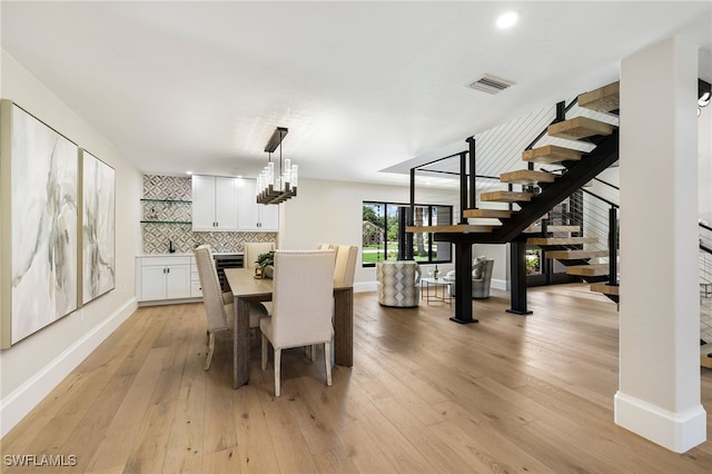 dining area featuring an inviting chandelier and light hardwood / wood-style flooring