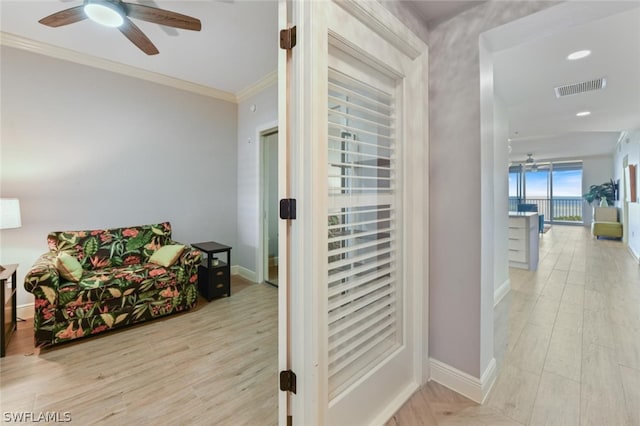 hallway with light hardwood / wood-style floors and ornamental molding