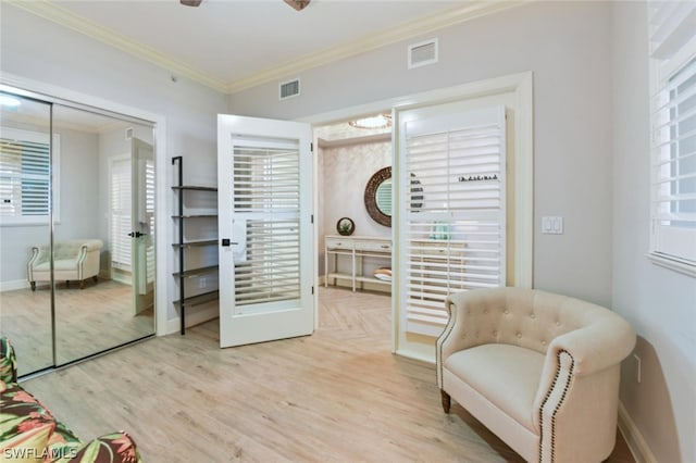 sitting room with ornamental molding, ceiling fan, and light hardwood / wood-style flooring