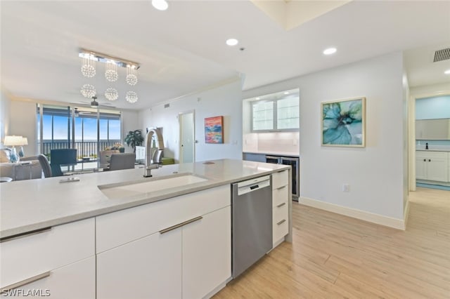 kitchen featuring white cabinetry, an inviting chandelier, sink, light wood-type flooring, and stainless steel dishwasher