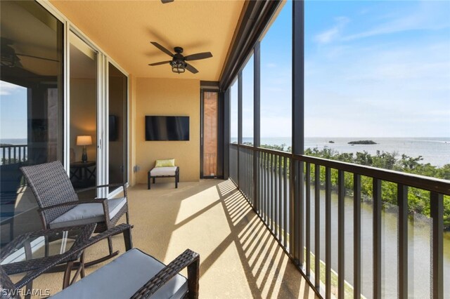 balcony featuring ceiling fan and a water view