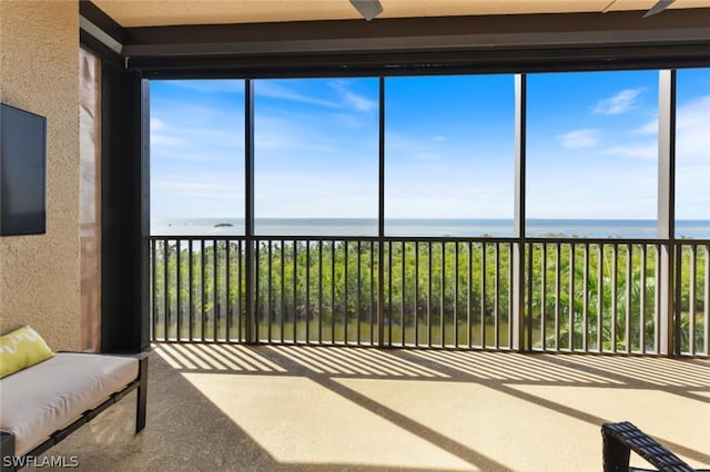 sunroom featuring a water view