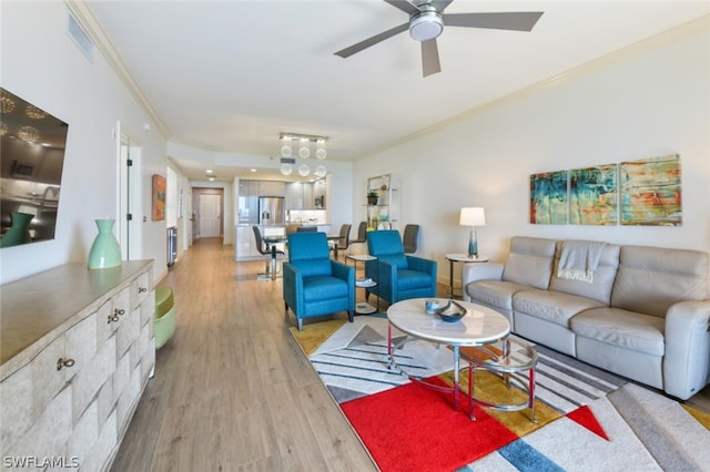 living room with rail lighting, light hardwood / wood-style flooring, ceiling fan, and ornamental molding