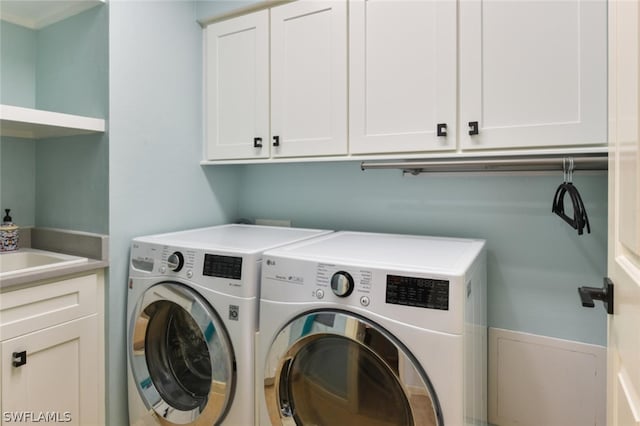 laundry area with cabinets and washing machine and clothes dryer