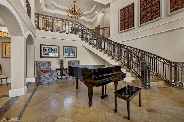 misc room featuring an inviting chandelier, ornamental molding, light tile floors, and a high ceiling