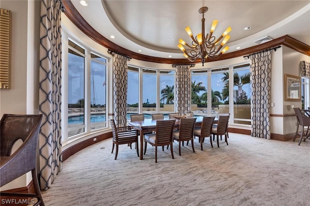 carpeted dining space with a raised ceiling and a notable chandelier