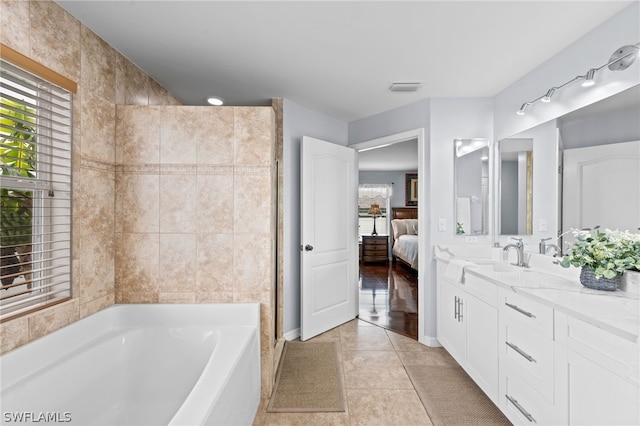 bathroom featuring tile patterned flooring, vanity, and a washtub