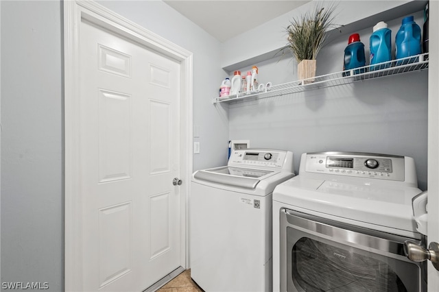 laundry room featuring light tile patterned floors and washing machine and clothes dryer