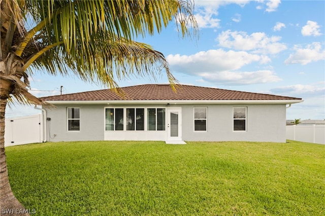 rear view of house featuring a lawn