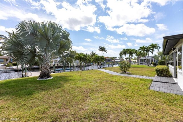 view of yard featuring a water view and a dock