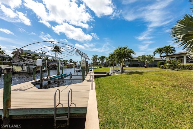 view of dock with a water view, boat lift, and a yard