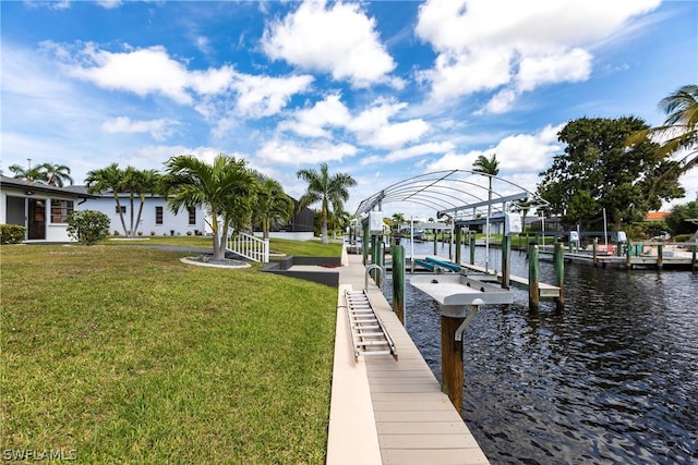 dock area with a water view, a lawn, and boat lift