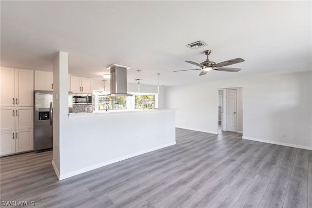 kitchen featuring stainless steel appliances, ceiling fan, white cabinetry, island exhaust hood, and light wood-type flooring