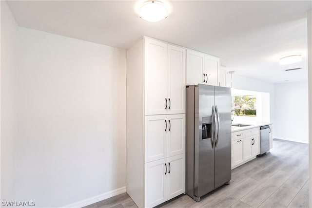 kitchen featuring white cabinets, stainless steel appliances, light wood-type flooring, and sink