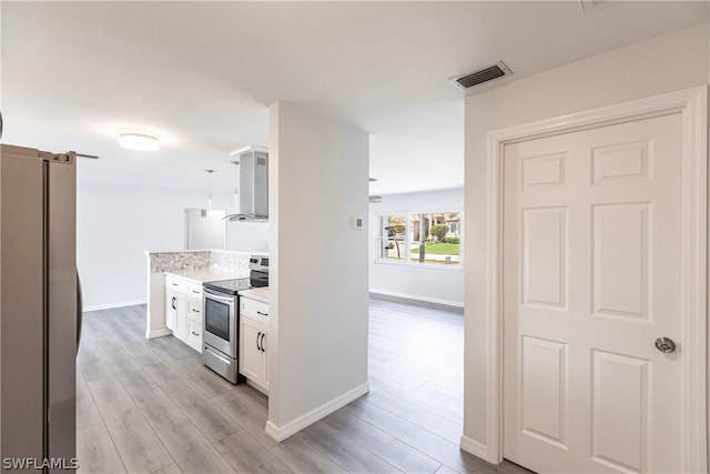 kitchen featuring white cabinets, hanging light fixtures, light wood-type flooring, and stainless steel appliances