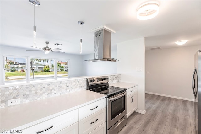 kitchen featuring decorative light fixtures, fume extractor, ceiling fan, appliances with stainless steel finishes, and backsplash