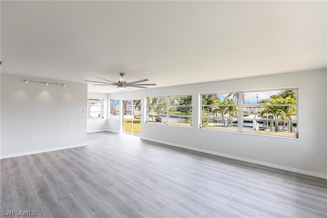 interior space featuring rail lighting, light hardwood / wood-style floors, and ceiling fan