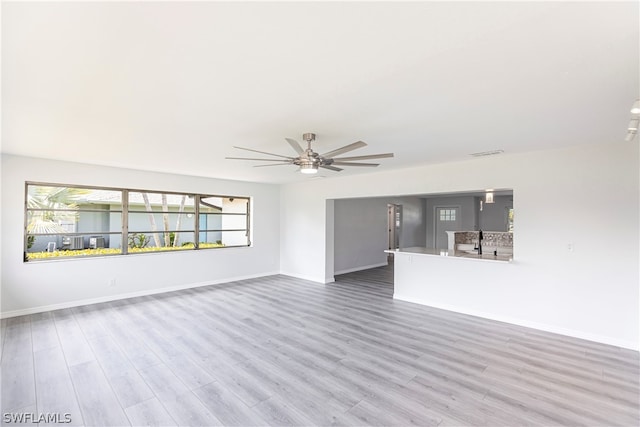 spare room with ceiling fan, light hardwood / wood-style flooring, and sink