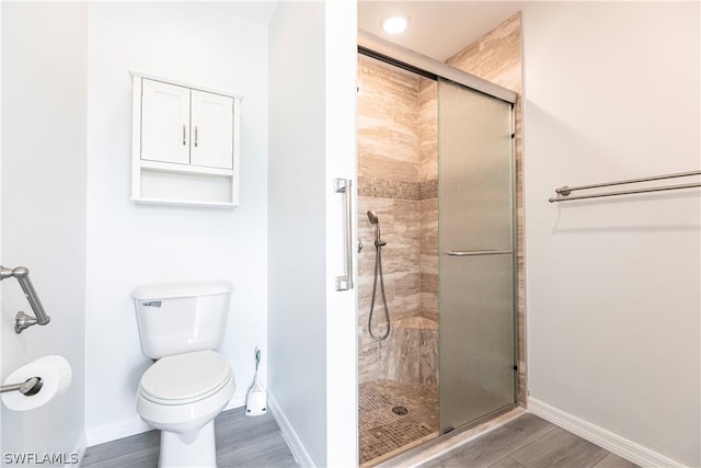 bathroom featuring toilet, an enclosed shower, and hardwood / wood-style flooring