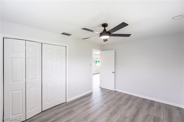 unfurnished bedroom featuring a closet, light hardwood / wood-style floors, and ceiling fan