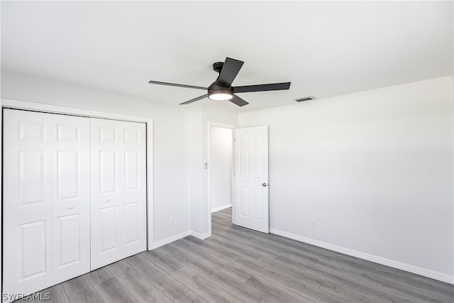 unfurnished bedroom featuring a closet, ceiling fan, and light wood-type flooring