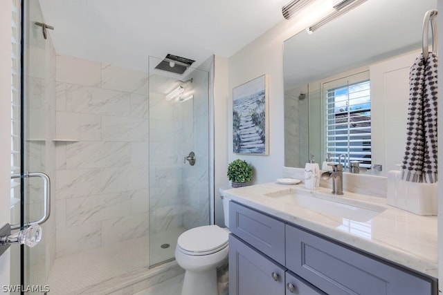 bathroom featuring toilet, a shower with door, and vanity with extensive cabinet space