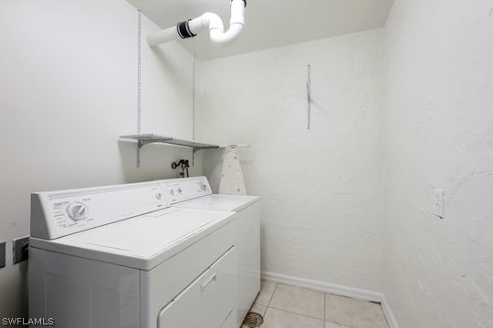 clothes washing area featuring washer / dryer and light tile flooring