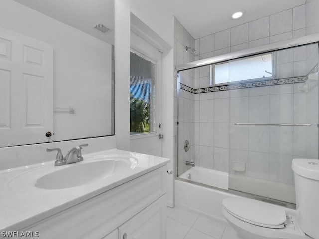 full bathroom with tile flooring, vanity with extensive cabinet space, enclosed tub / shower combo, and toilet