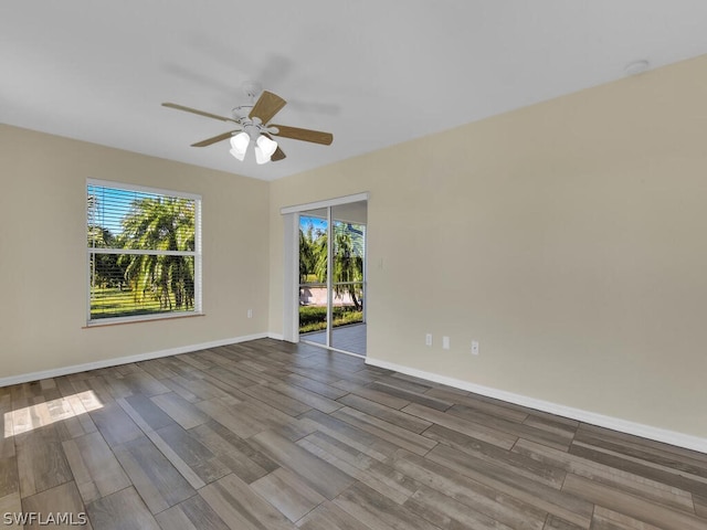 spare room with wood-type flooring, ceiling fan, and a wealth of natural light