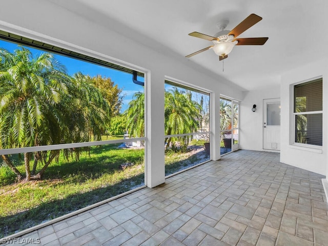 unfurnished sunroom featuring ceiling fan