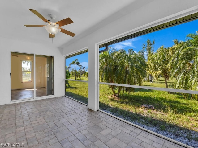 unfurnished sunroom featuring ceiling fan