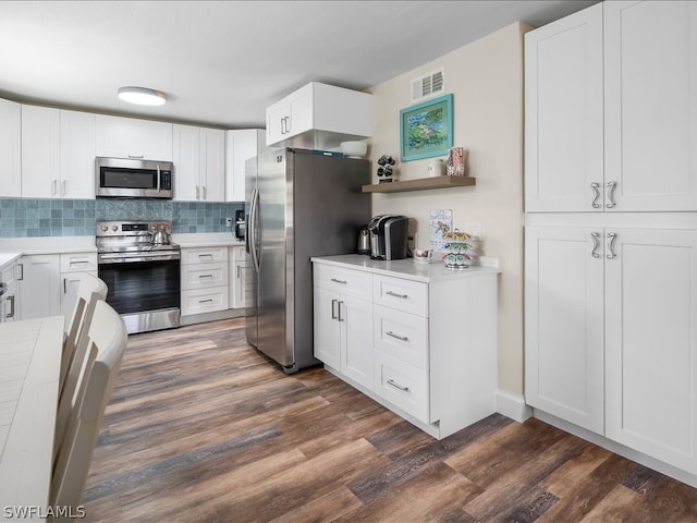 kitchen featuring appliances with stainless steel finishes, dark hardwood / wood-style floors, backsplash, and white cabinetry