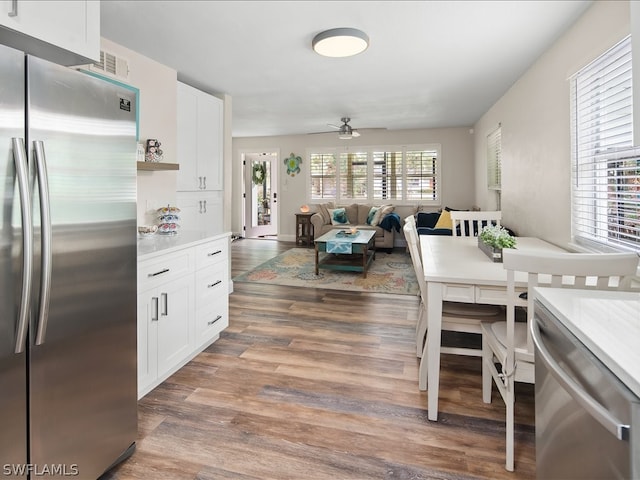 kitchen with white cabinetry, dark hardwood / wood-style floors, ceiling fan, and stainless steel fridge