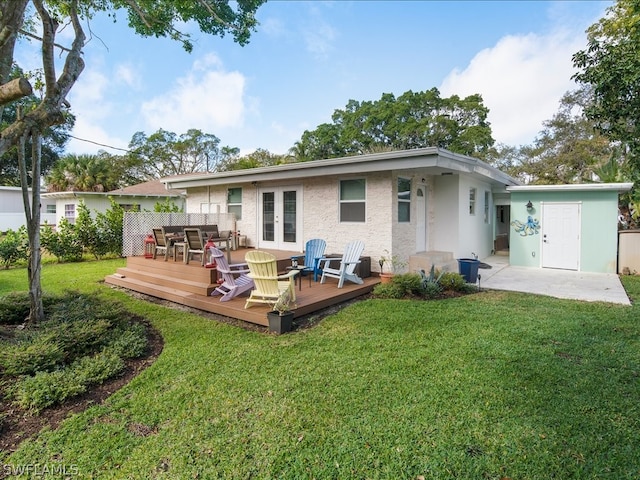 back of house featuring a yard, a wooden deck, and french doors