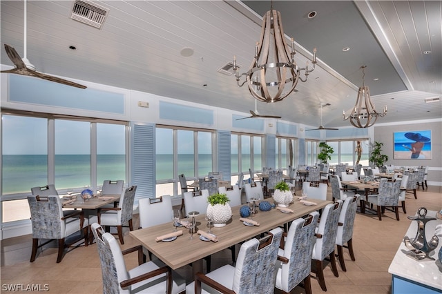 tiled dining area with a chandelier, a water view, and wood ceiling