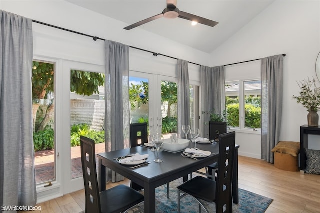 dining room featuring ceiling fan, light wood-type flooring, high vaulted ceiling, and french doors